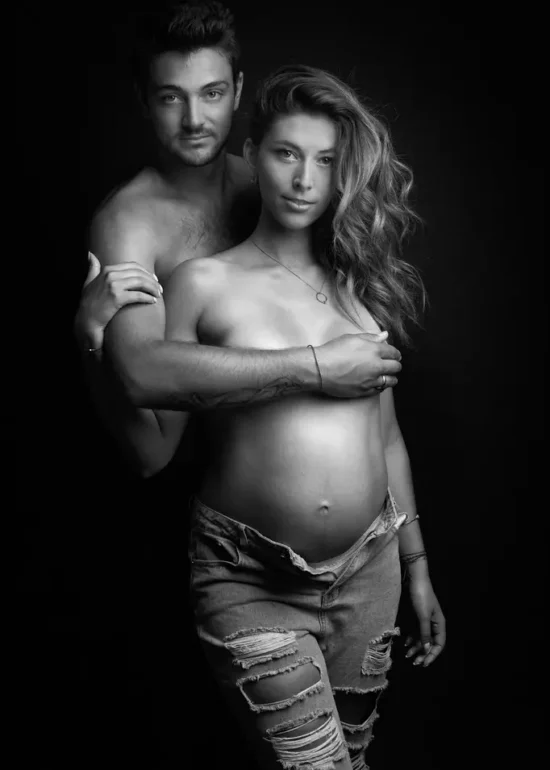 portrait d'un couple avec une femme enceinte. En noir et blanc, elle porte un jean déchiré