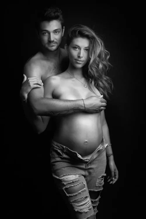 portrait d'un couple avec une femme enceinte. En noir et blanc, elle porte un jean déchiré