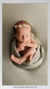 bébé avec accessoires portant une couronne de fleur et wrappé dans un tissu vert