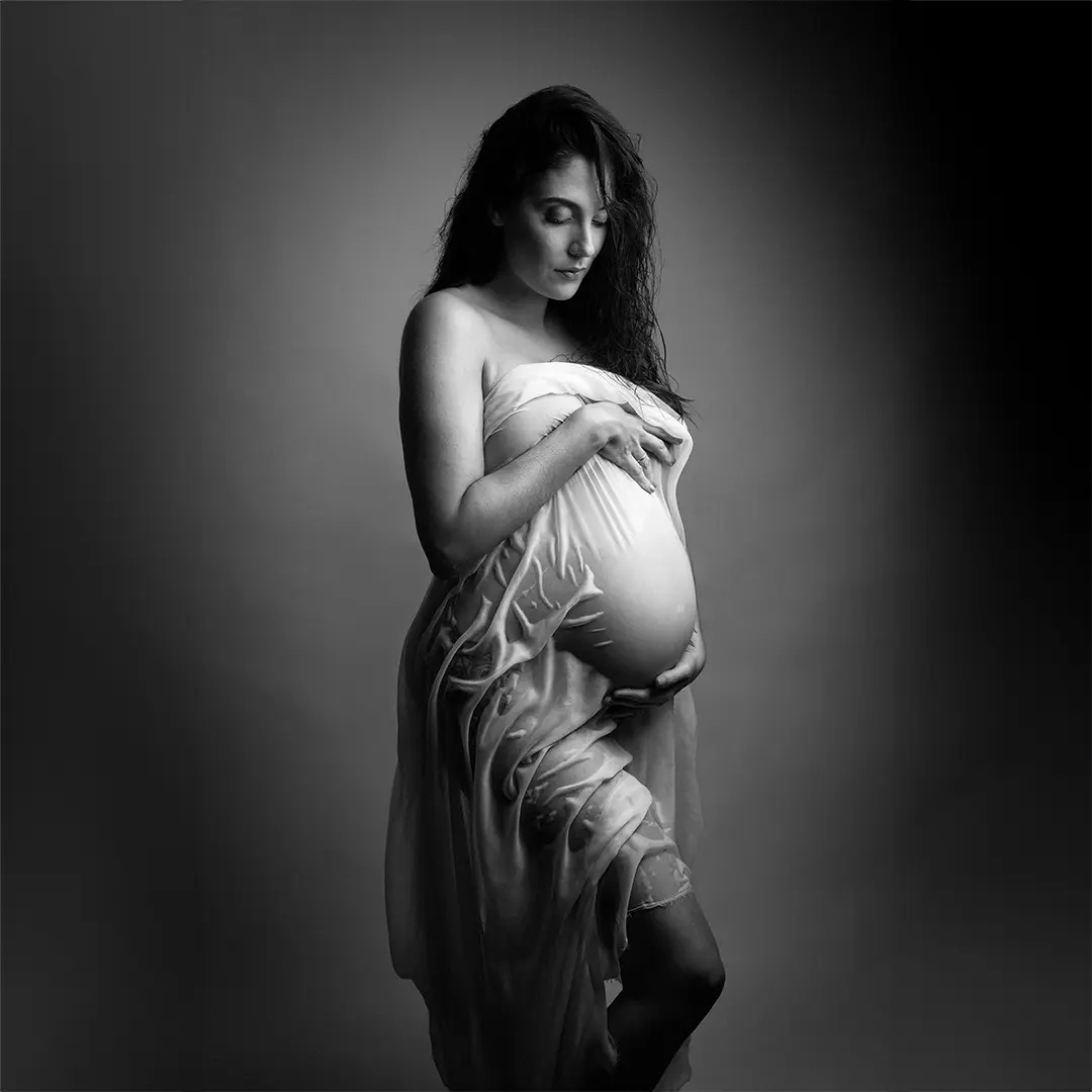 shooting grossesse, femme porte un drap mouillé sur le corps pour mettre en valeur son ventre